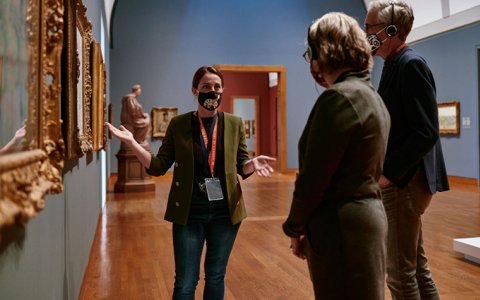 A Gallery employee giving a tour to a group of people.